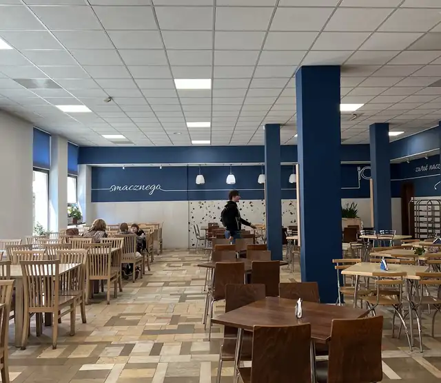 Duża sala Baru Małgośka z granatowymi kolumnami i rzędami stolików