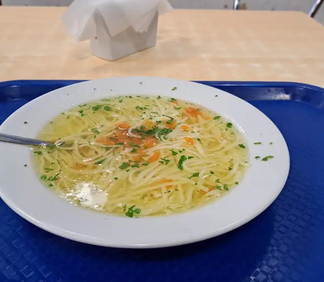 Rosół z makaronem na niebieskiej tacy